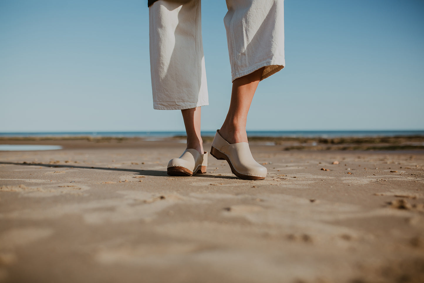girl wears stone beige low heel clog with covered back