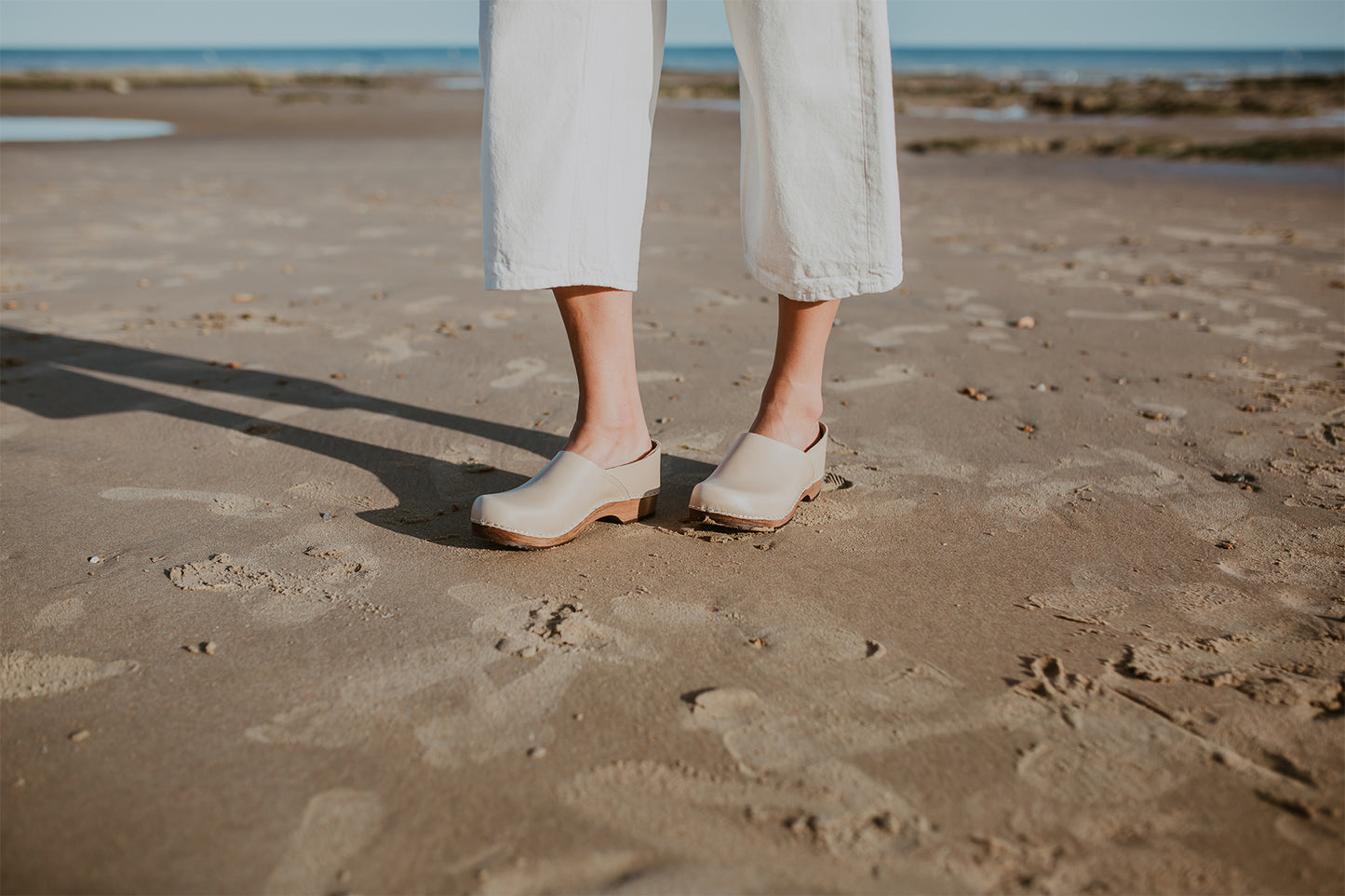 girl wears stone beige low heel clog with covered back
