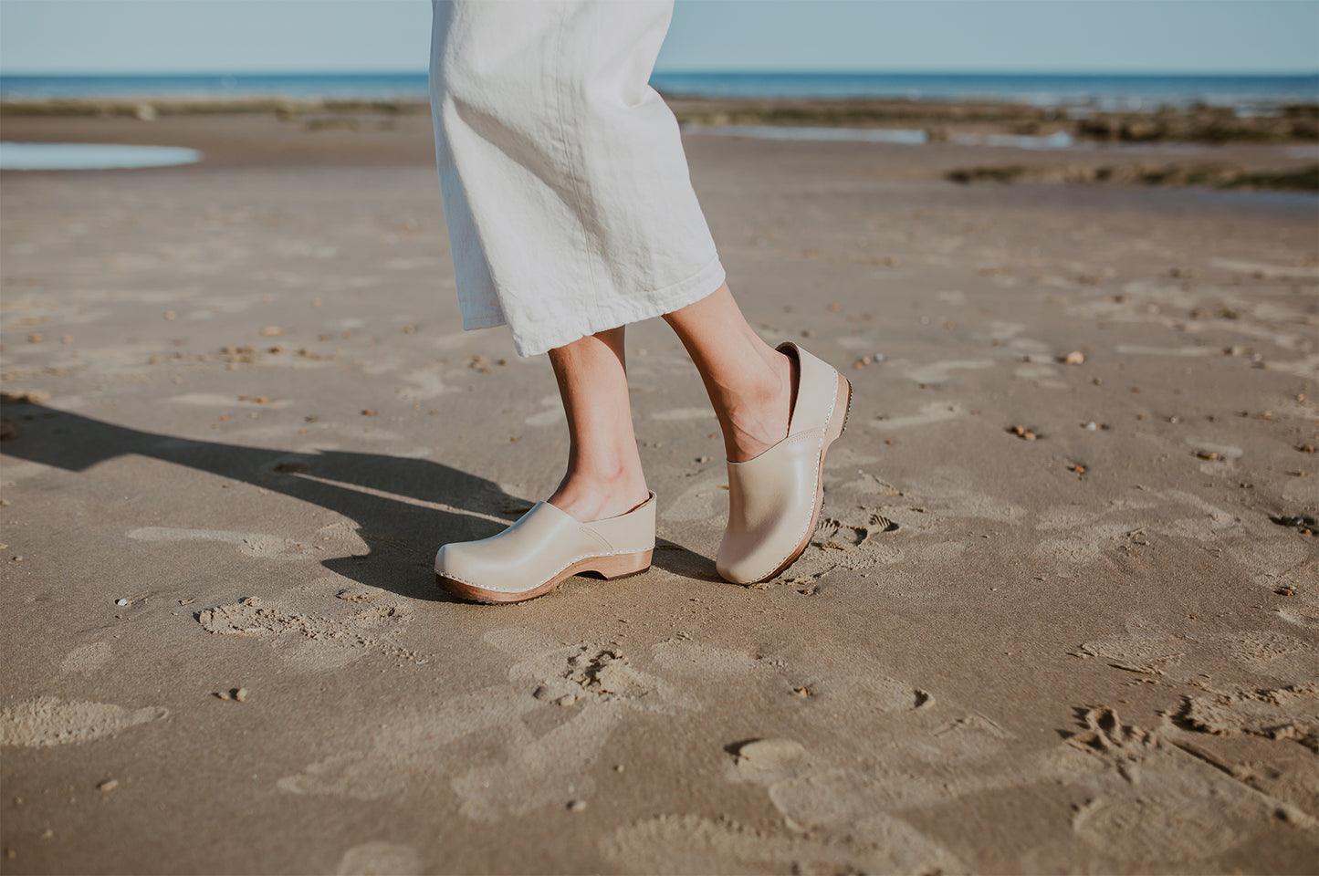 girl wears stone beige low heel clog with covered back