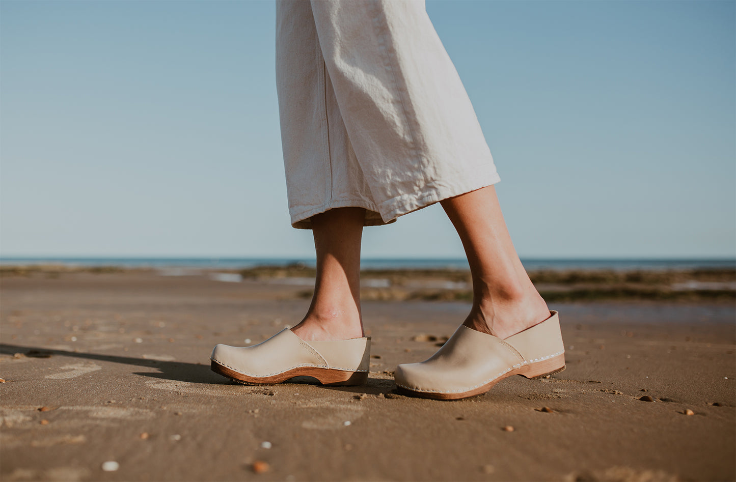 girl wears stone beige low heel clog with covered back