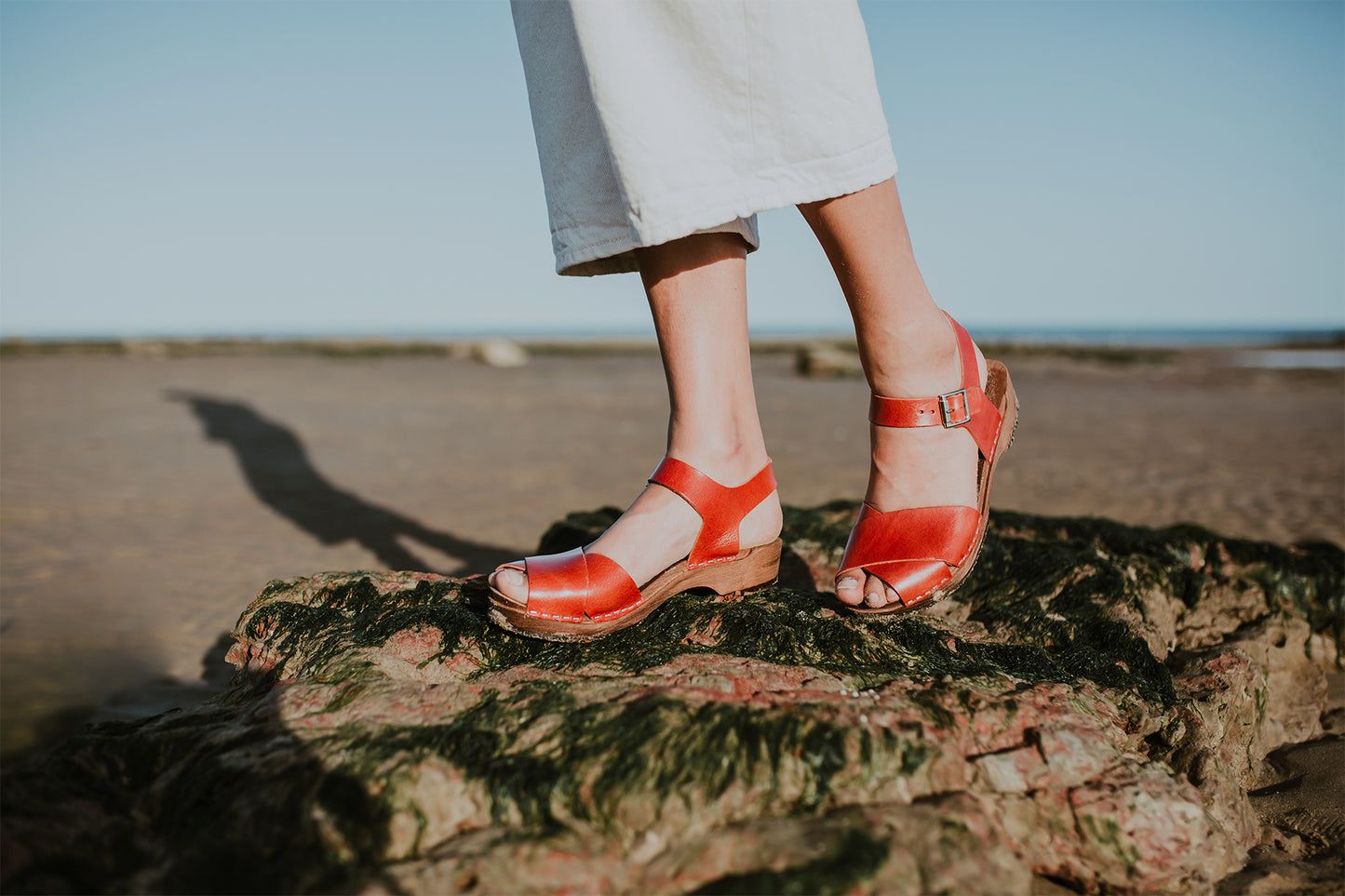 woman wears brandy red leather low cross over dansare clog sandal