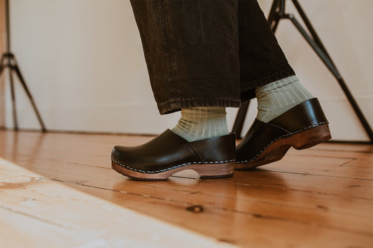 close up of woman's feet in sage green ribbed ankle socks and onyx low heel clog shoe