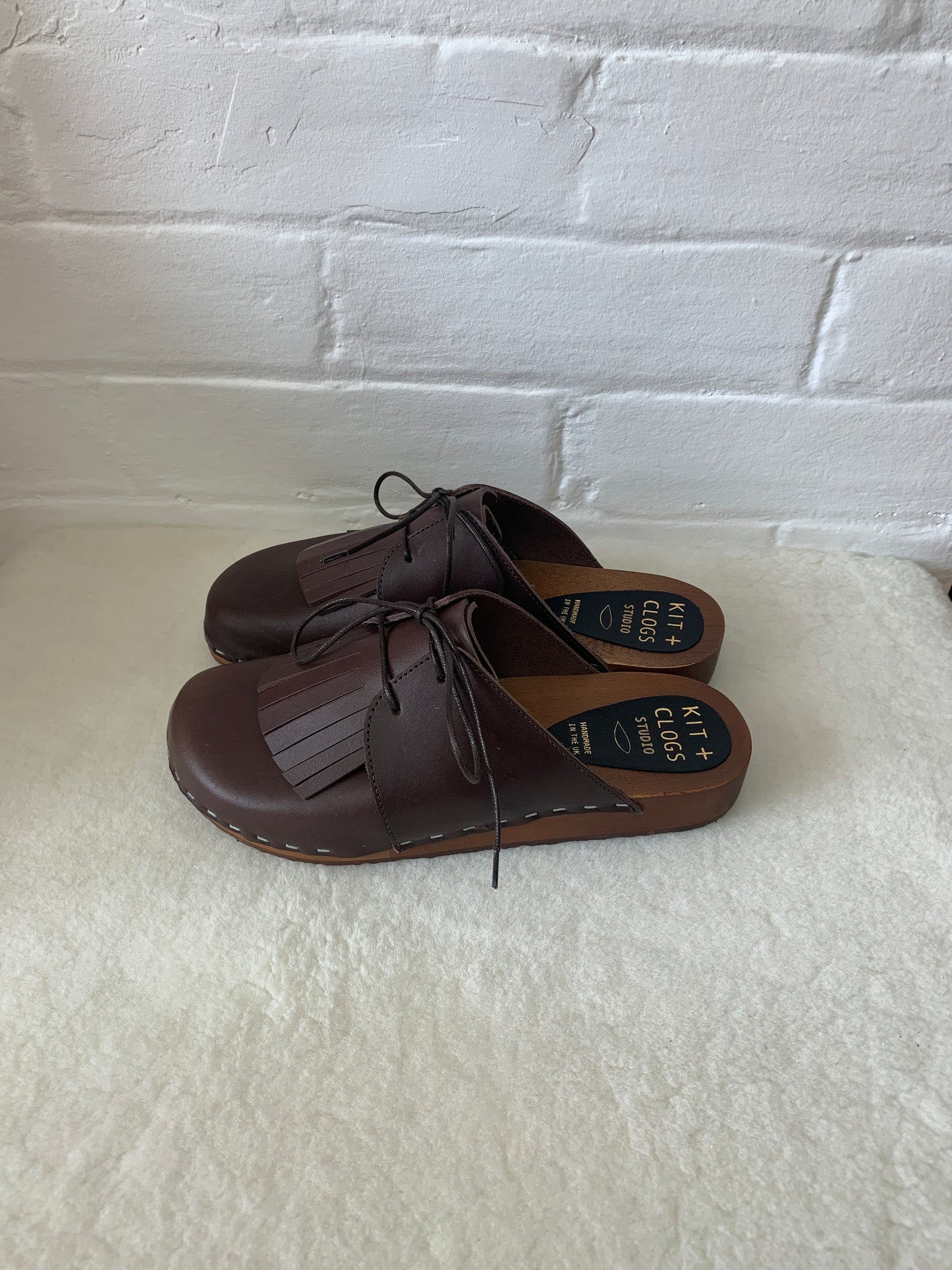 brown leather lace up clog mules with removable fringe tongue and flexible wooden base