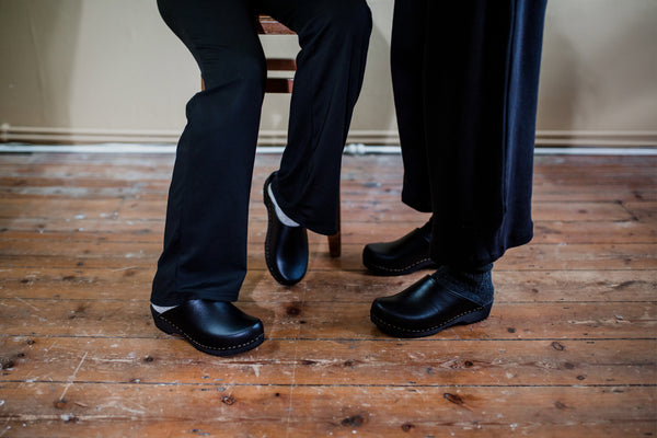 black classic style swedish clogs with a low black wooden base
