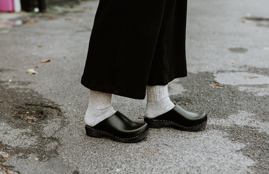 black classic style swedish clogs with a low black wooden base