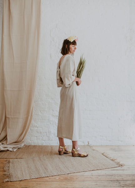 Gold metallic cross over sandal clog with ankle strap and a mid heel bridal