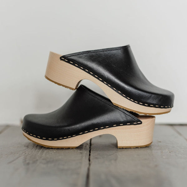 black womens swedish clog mules with a sleek light coloured mid heel