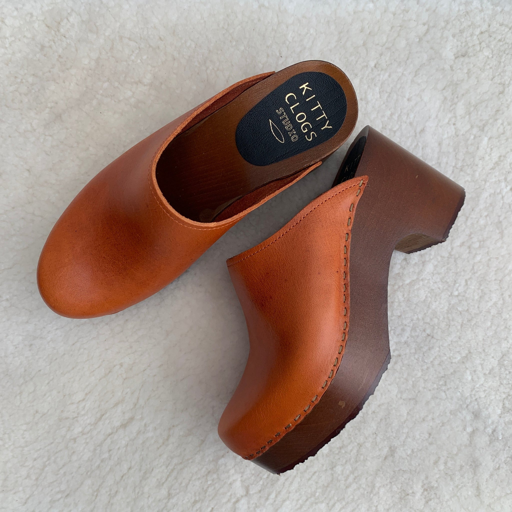 Cumin tan orange classic style swedish clogs with a dark platform base.