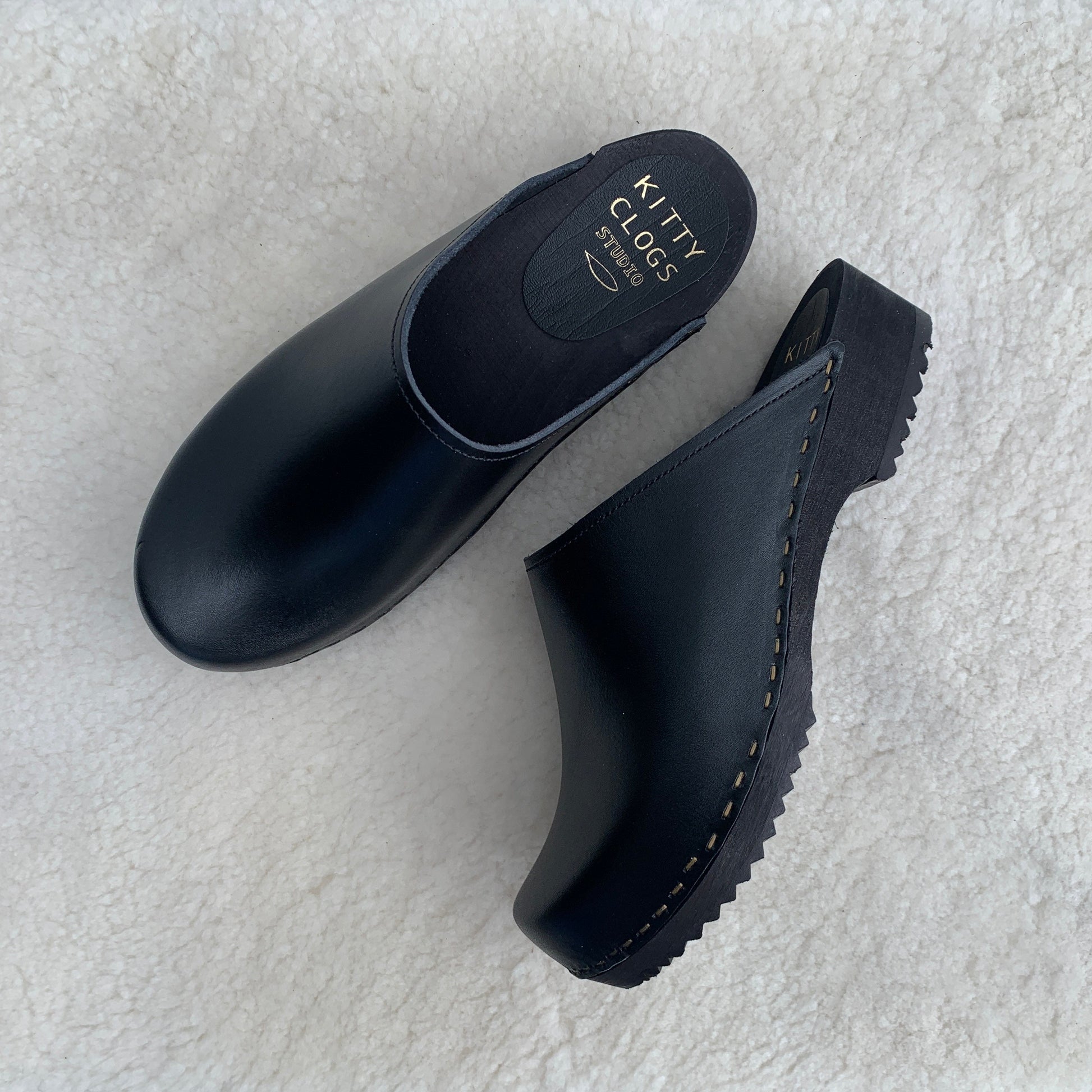 black classic style swedish clogs with a low black wooden base