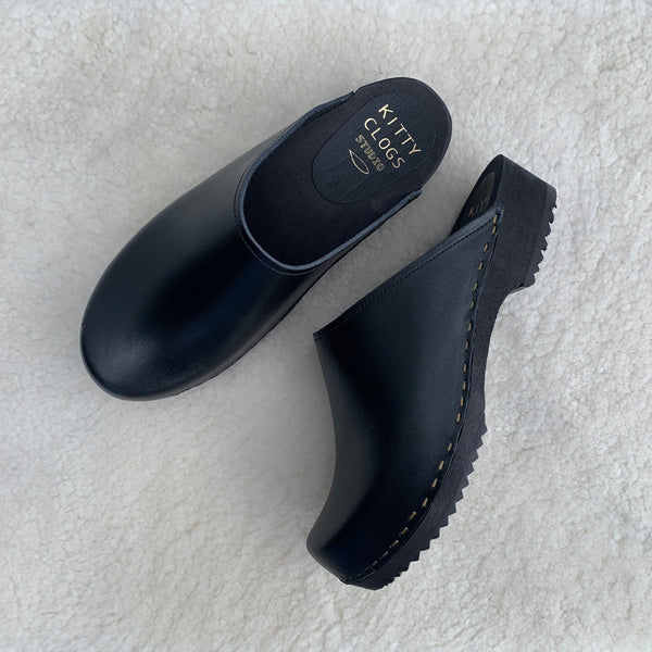 black classic style swedish clogs with a low black wooden base