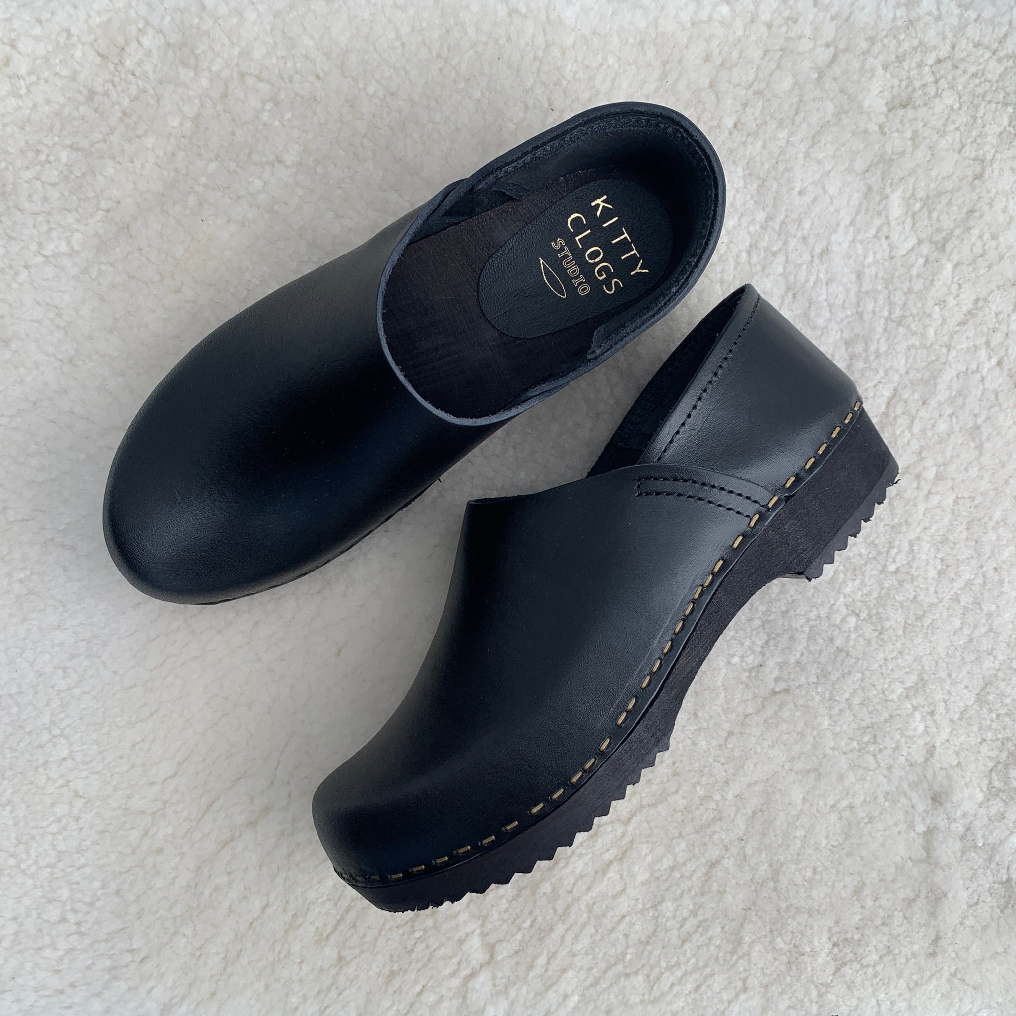 Black covered back swedish clogs with black base