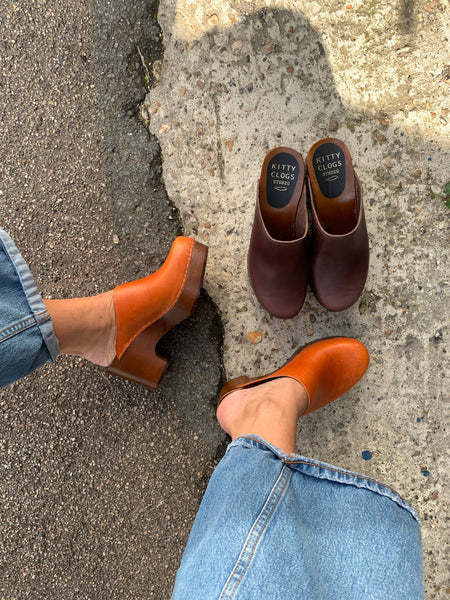 Cumin tan orange classic style swedish clogs with a dark platform base.