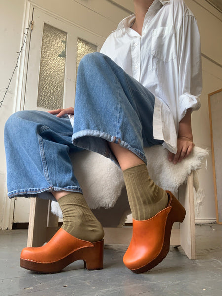 Cumin tan orange classic style swedish clogs with a dark platform base.