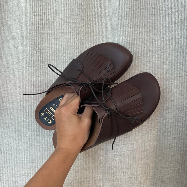 brown leather lace up clog mules with removable fringe tongue and flexible wooden base