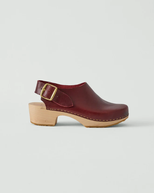 Maroon clog shoe on a gray background with a computer interface in the background.