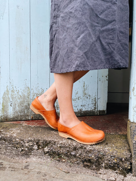 Cumin tan swedish clogs with a low wooden base and covered back