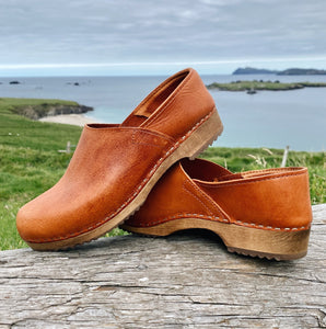 Cumin tan swedish clogs with a low wooden base and covered back