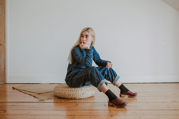 girl wears denim jumpsuit with her socks in onyx and garnet low Klassisk clog