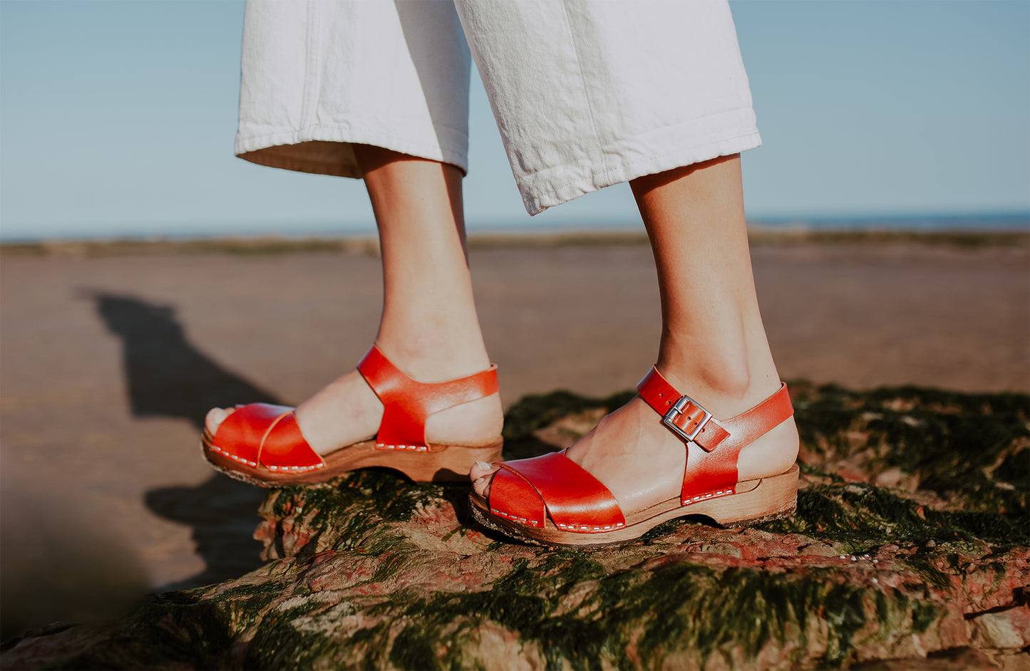 woman wears brandy red leather low cross over dansare clog sandal