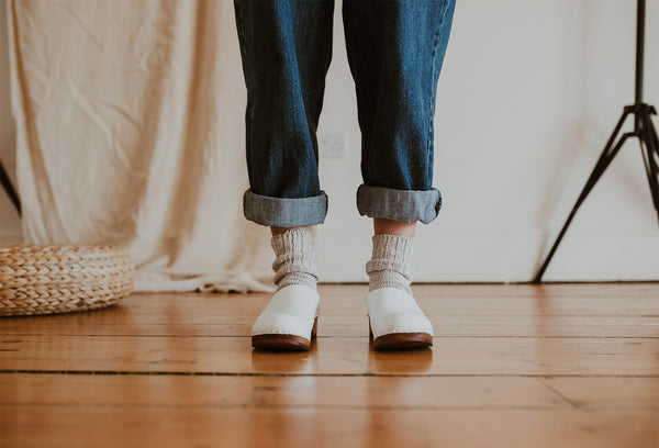 close up of woman's feet in Organic, recycled cotton socks in a flecked ash grey and cream colour with a ribbed ankle and Ice Low Klassisk clogs