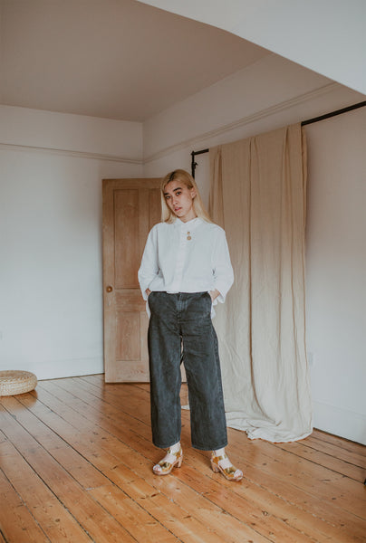 girl wears white shirt with black wide leg jeans and gold mid heel clog sandals