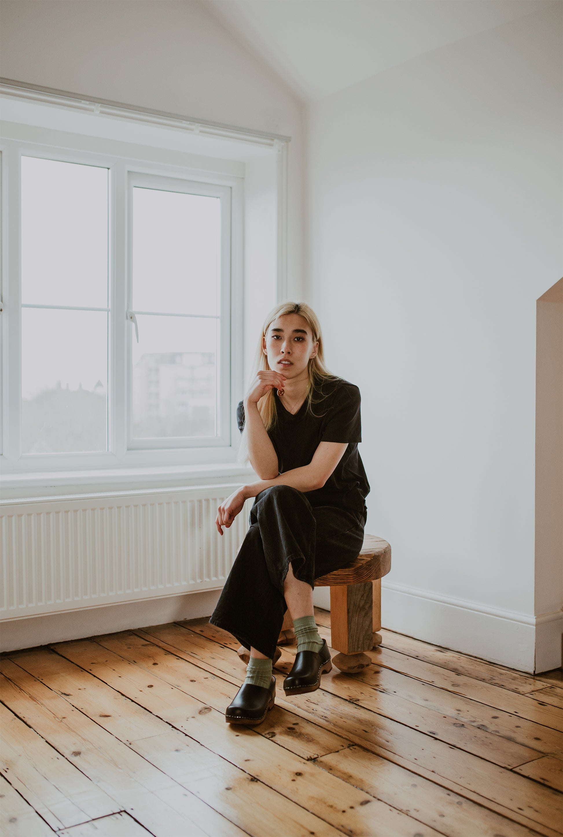 girl wears black jeans with sage green ribbed ankle socks and onyx low heel clog shoe