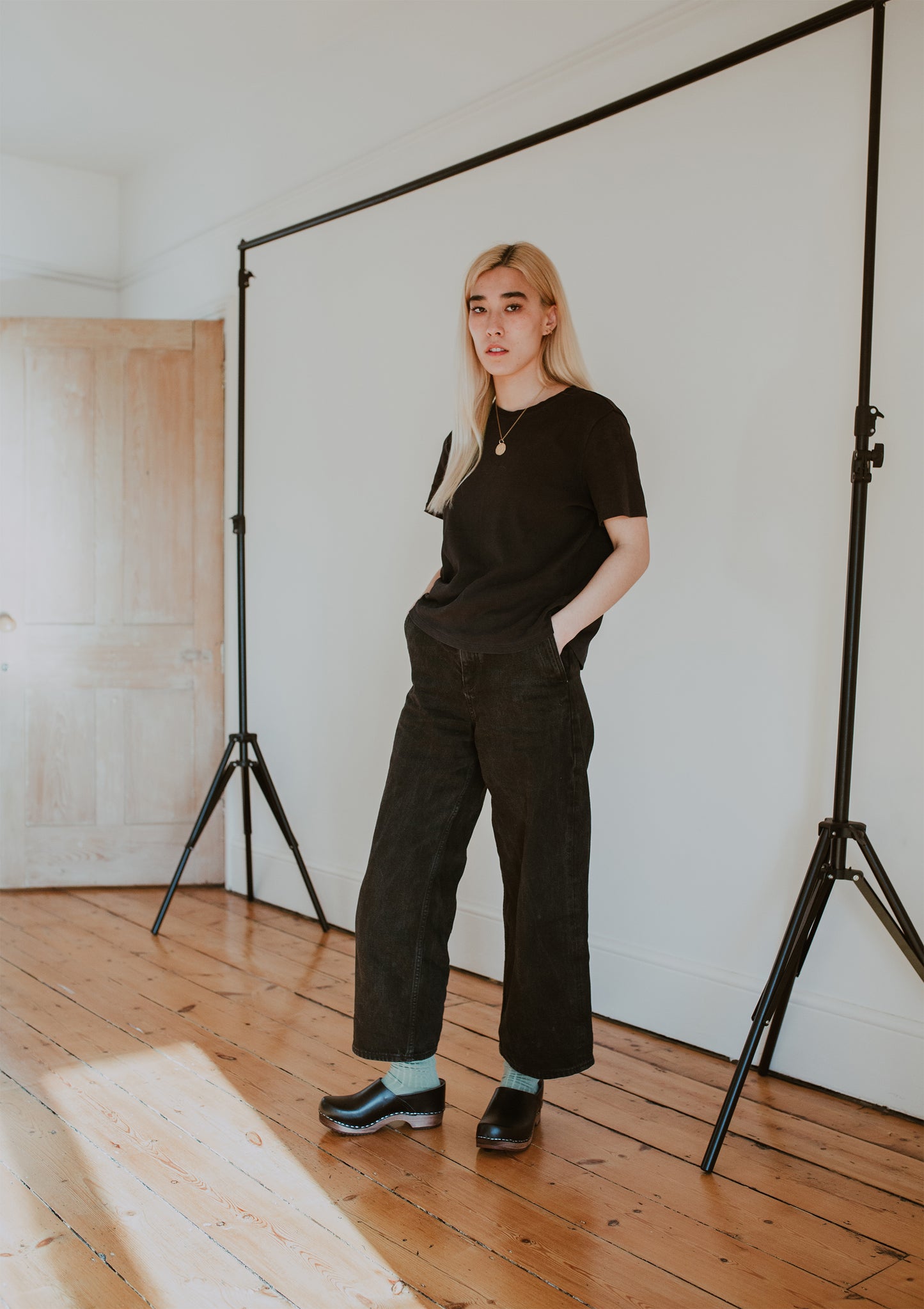 girl wears black jeans with sage green ribbed ankle socks and onyx low heel clog shoe