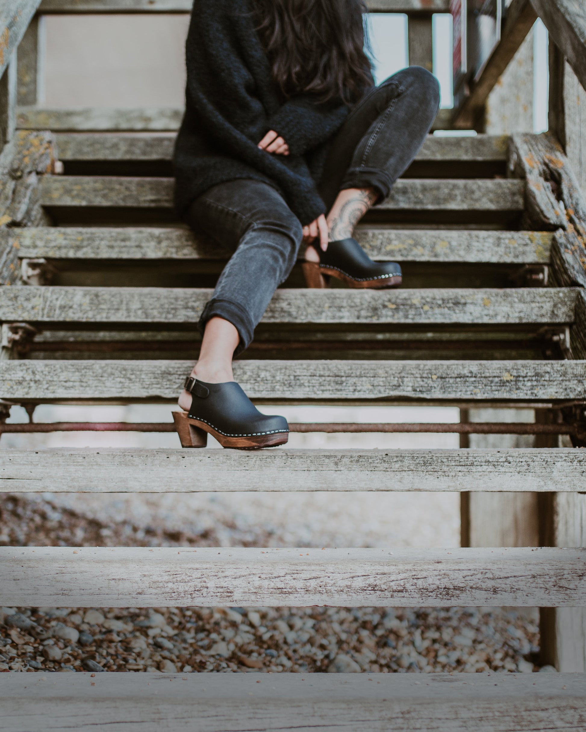 close up of woman's feet in black mid heel women's classic style kliva clog with ankle strap