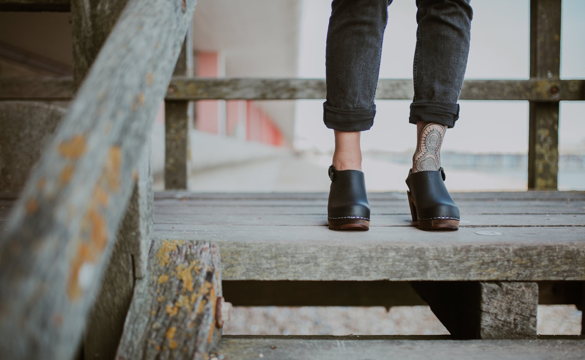 close up of woman's feet in black mid heel women's classic style kliva clog with ankle strap