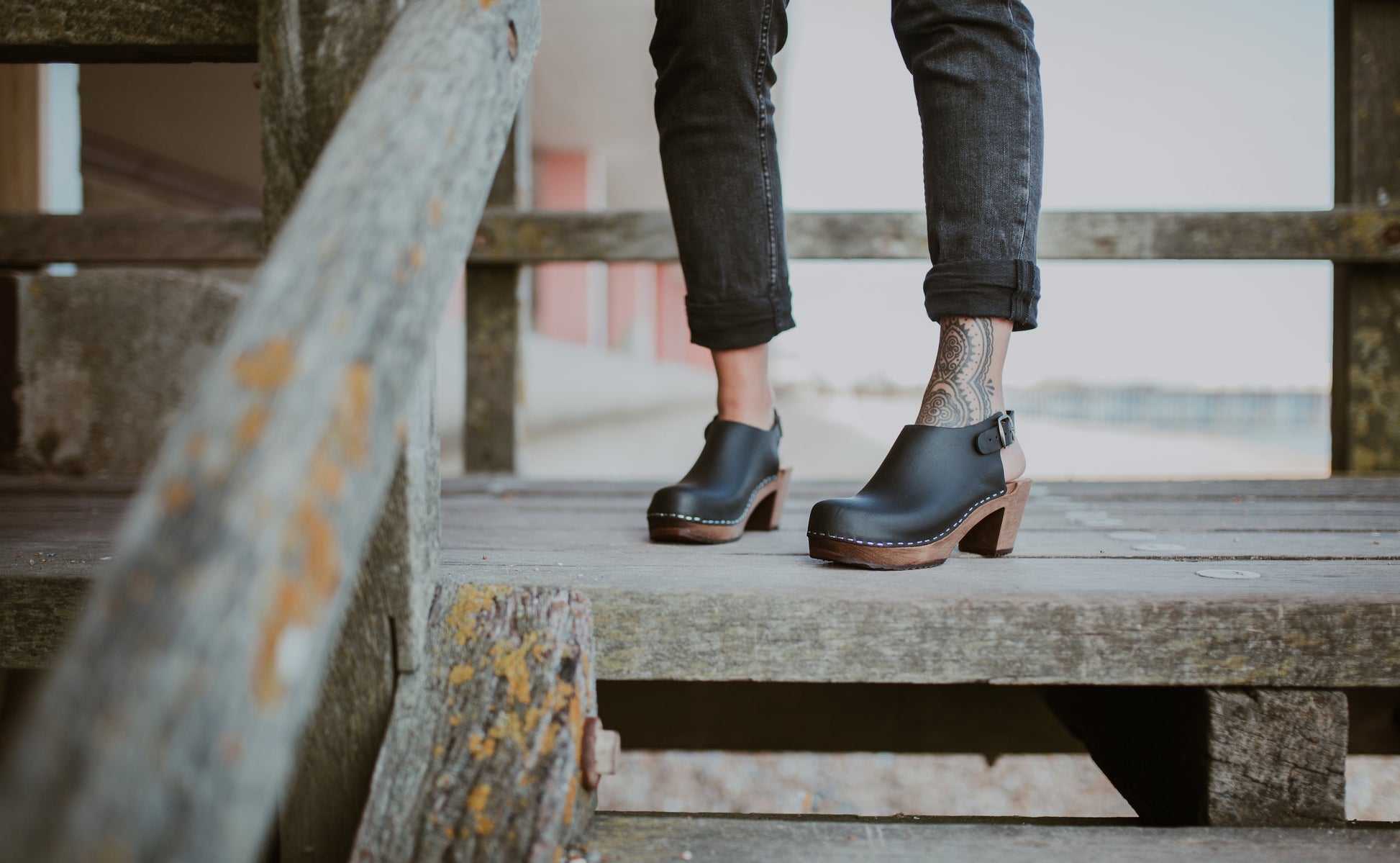 close up of woman's feet in black mid heel women's classic style kliva clog with ankle strap