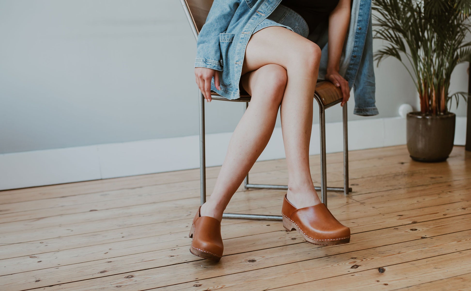 close up of woman's feet in tan cumin low heel classic style swedish clog with a covered back