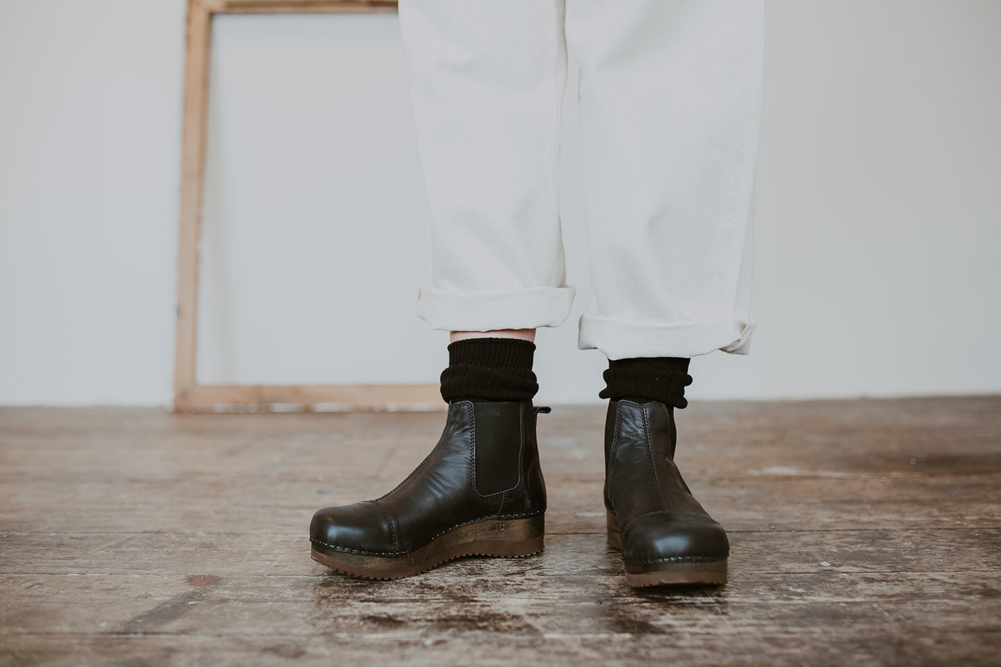 Close up of woman's feet in Black leather chelsea clog boot with flex sole