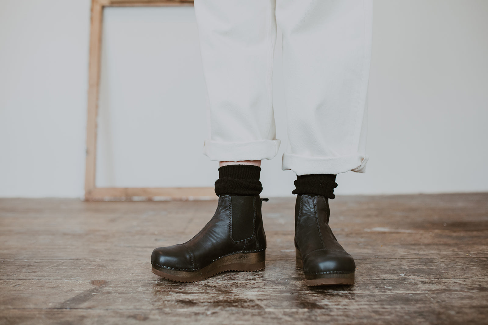 Close up of woman's feet in Black leather chelsea clog boot with flex sole