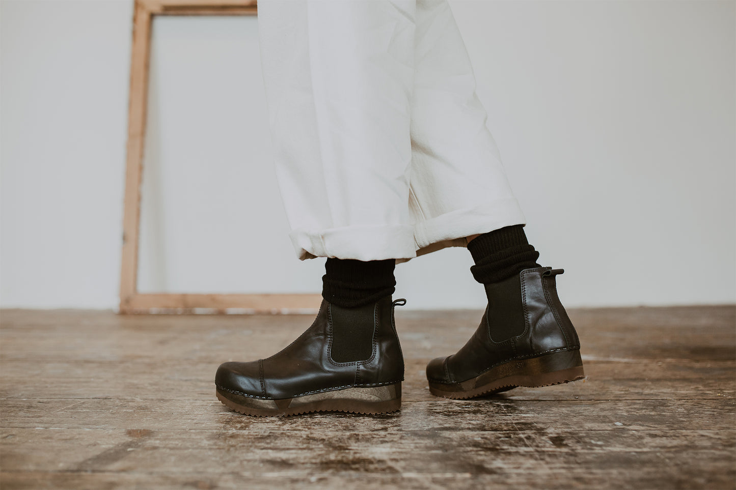 Close up of woman's feet in Black leather chelsea clog boot with flex sole