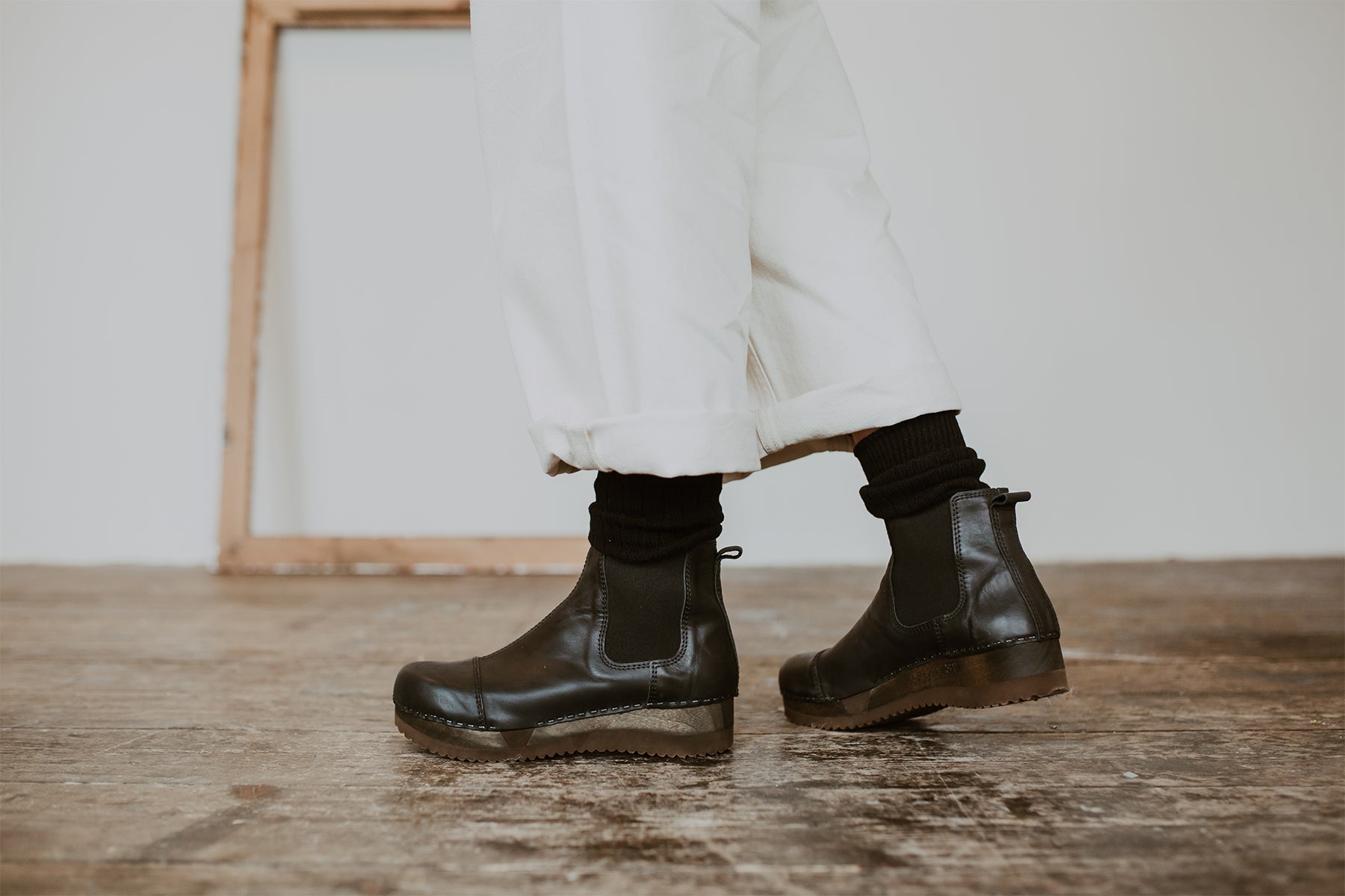 Close up of woman's feet in Black leather chelsea clog boot with flex sole