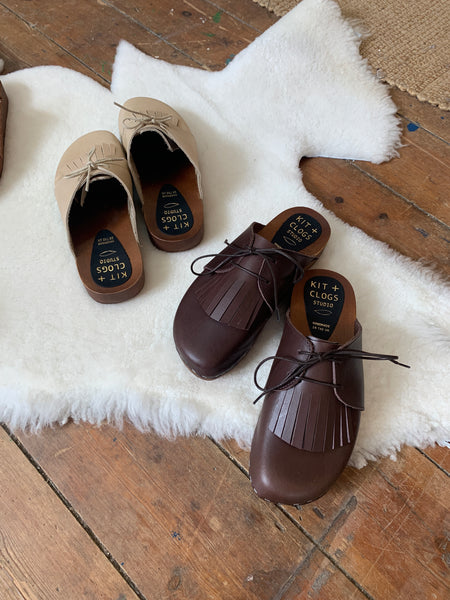 brown leather lace up clog mules with removable fringe tongue and flexible wooden base
