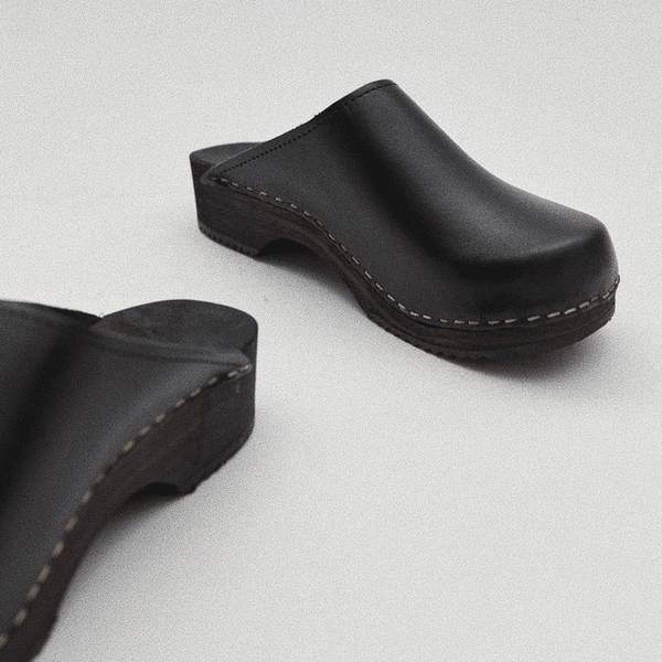 black classic style swedish clogs with a low black wooden base