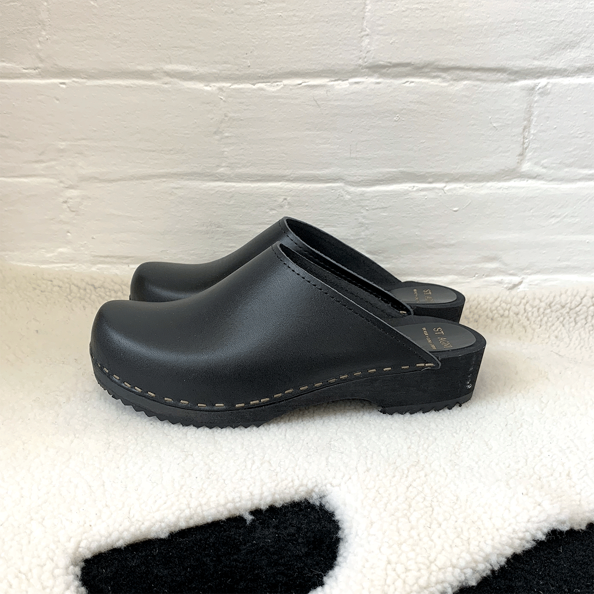 black classic style swedish clogs with a low black wooden base