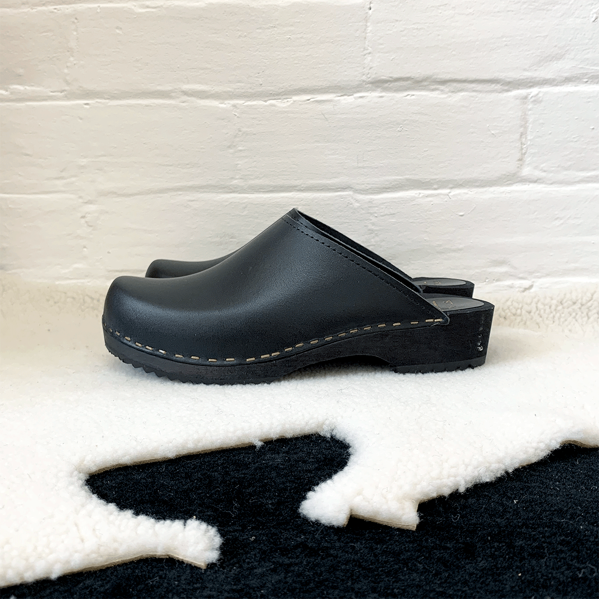 black classic style swedish clogs with a low black wooden base